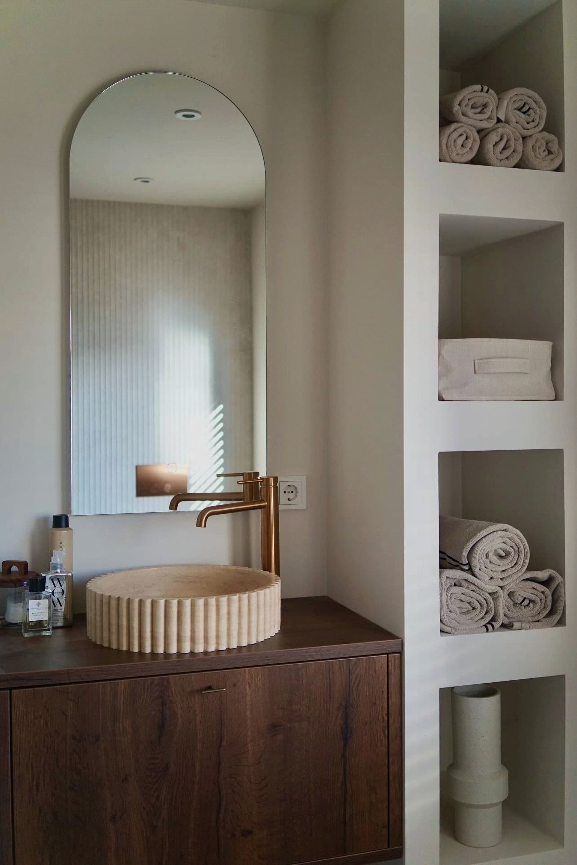 Travertin waskom in een warme badkamer